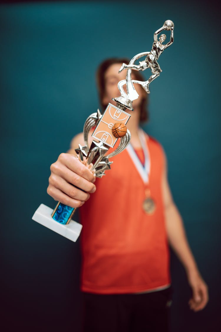 Shallow Focus Of A Person Holding A Trophy