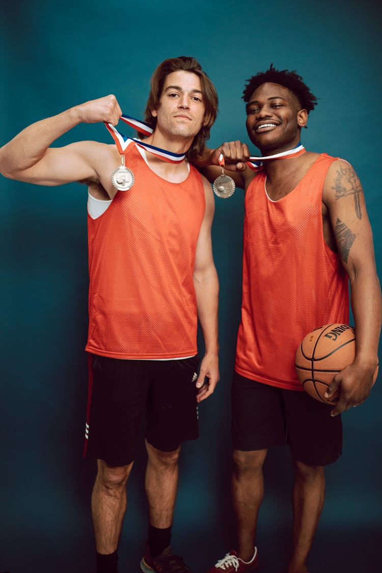 Basketball Players Posing Together While Holding Their Medals