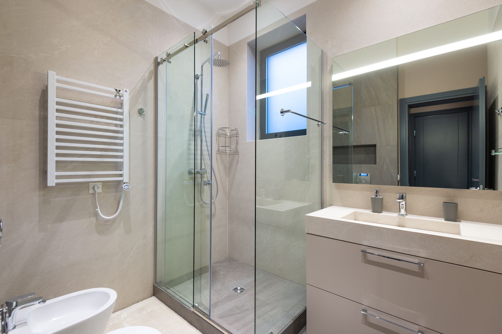 A calm, modern shower and mirror in a residential bathroom