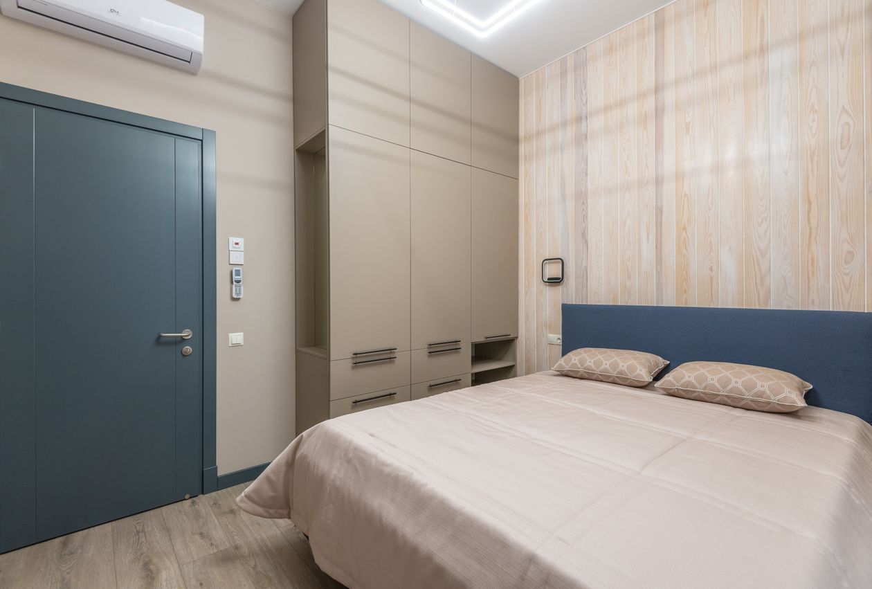 Wardrobe placed on the side wall of a small bedroom.