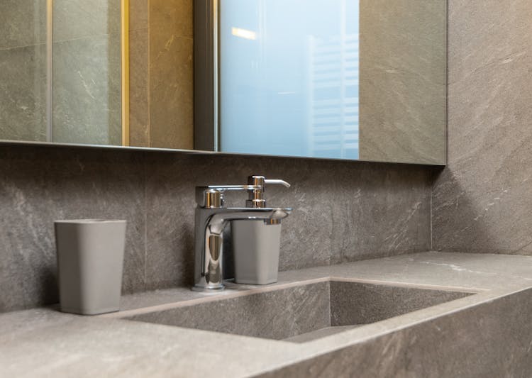 Details Of Contemporary Bathroom With Marble Tiles And Mirror