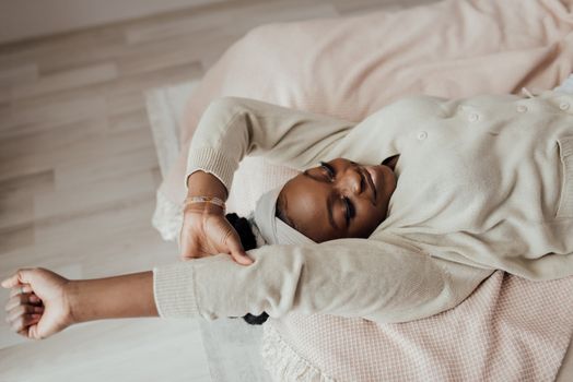 Peaceful woman stretching on a bed, embracing morning relaxation and comfort.
