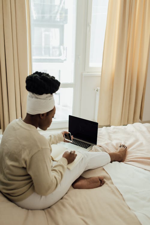 Free A Woman Writing on a Notebook while in Bed Stock Photo