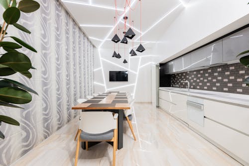 Minimalist interior of illuminated kitchen with dining zone