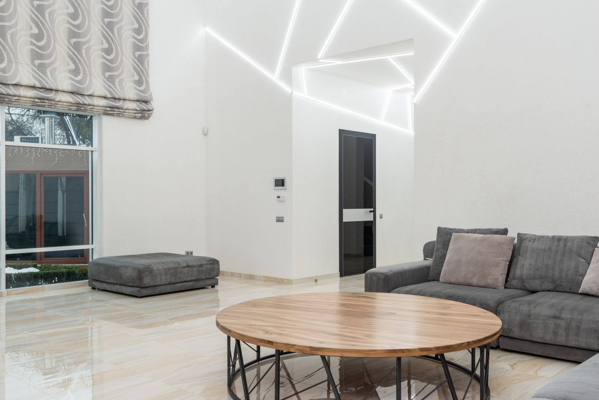 Explore a spacious minimalist living room with modern furniture and elegant lighting design.