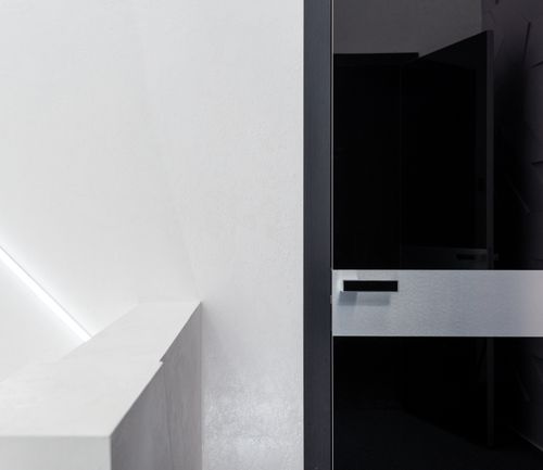Free Contemporary black door with handle against fence and glowing lamp on white wall in house Stock Photo