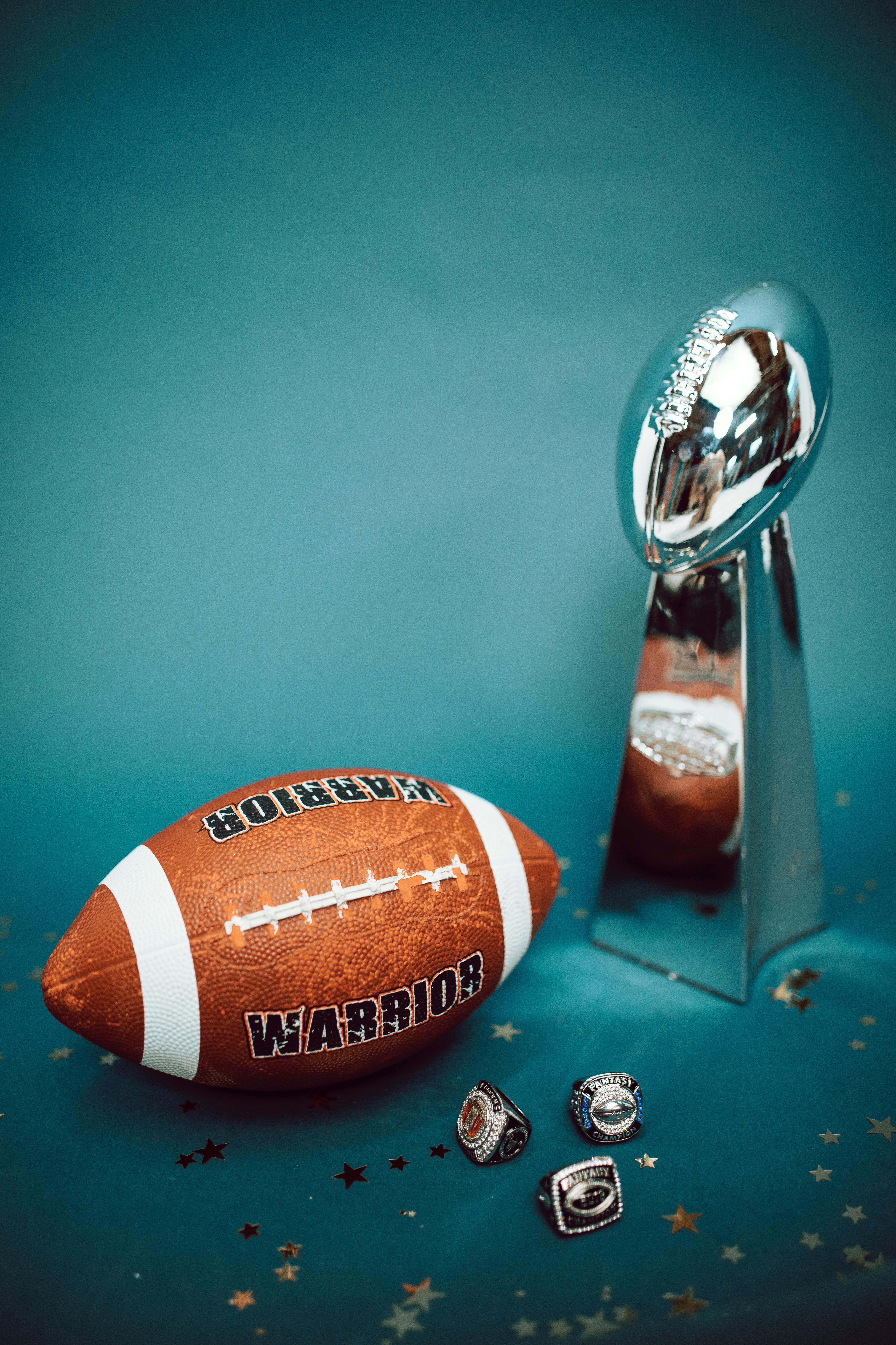 a pigskin football and a vince lombardi trophy