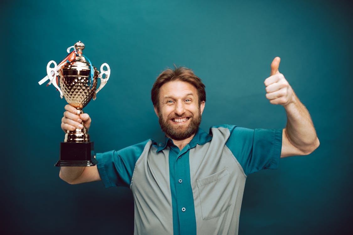 Free A Man's Face of Victory Holding His Trophy Stock Photo