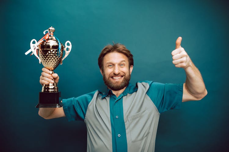 A Man's Face Of Victory Holding His Trophy