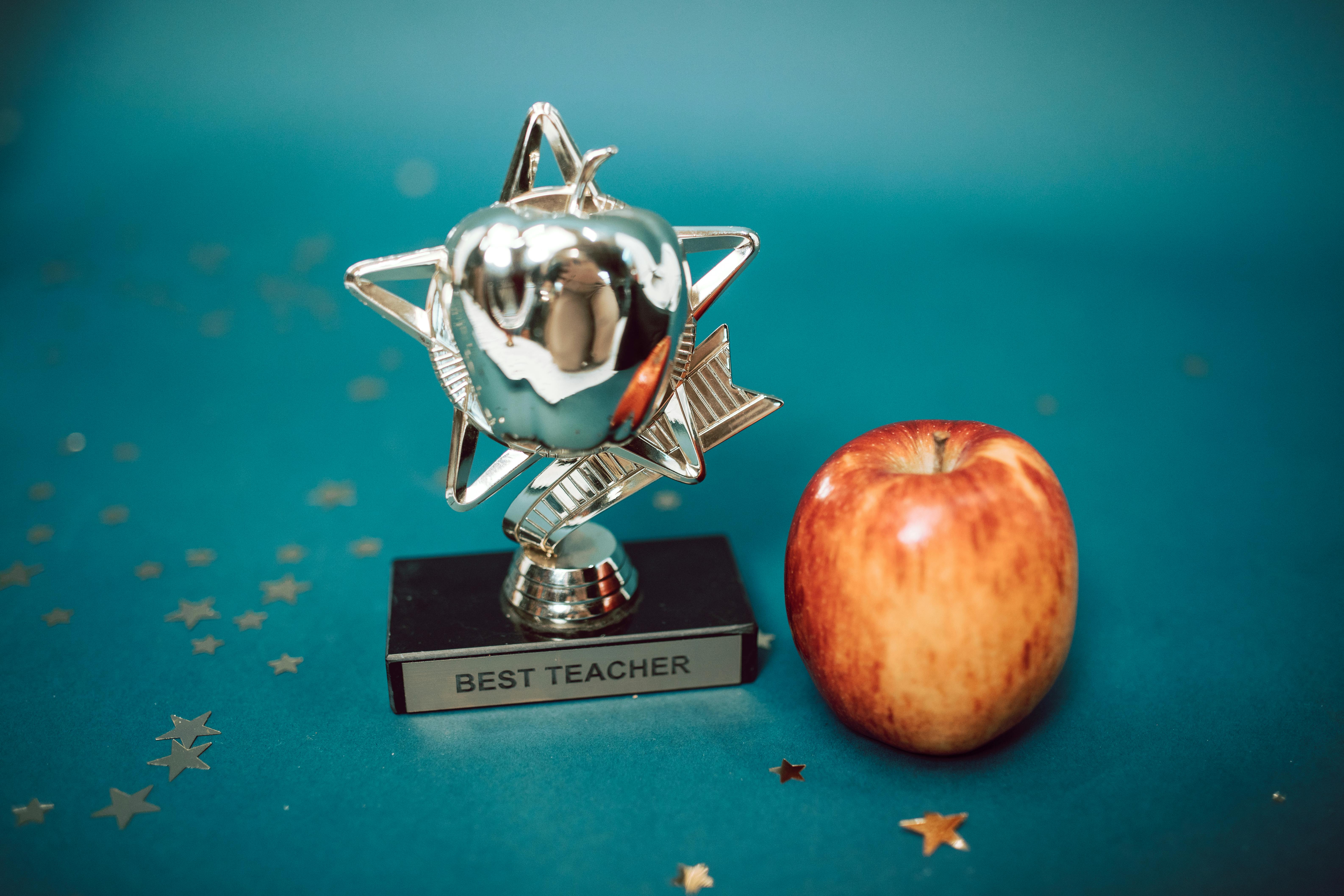 a best teacher award beside an apple