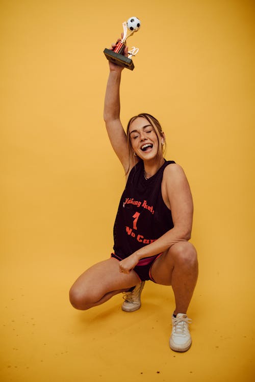 A Woman in a Black Tank Top Holding a Trophy