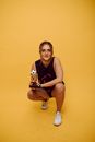 A Woman Crouching while Holding a Trophy
