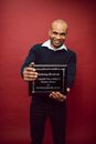 A Smiling Man Holding a Certificate of Appreciation