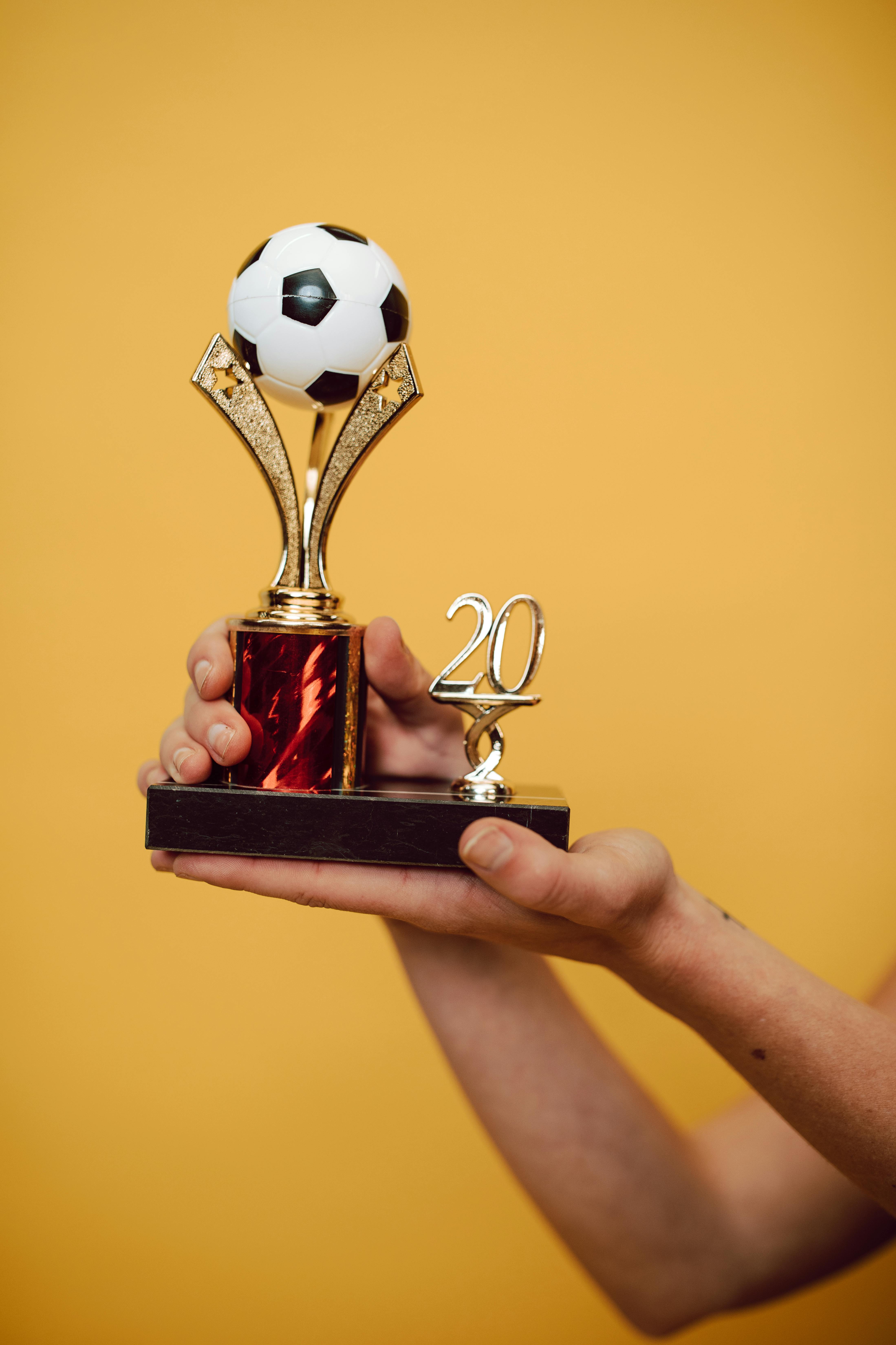 a person holding a soccer trophy