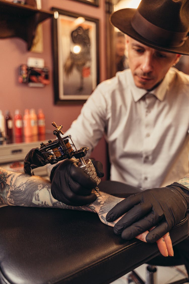 Close-up Of A Man Tattooing An Arm