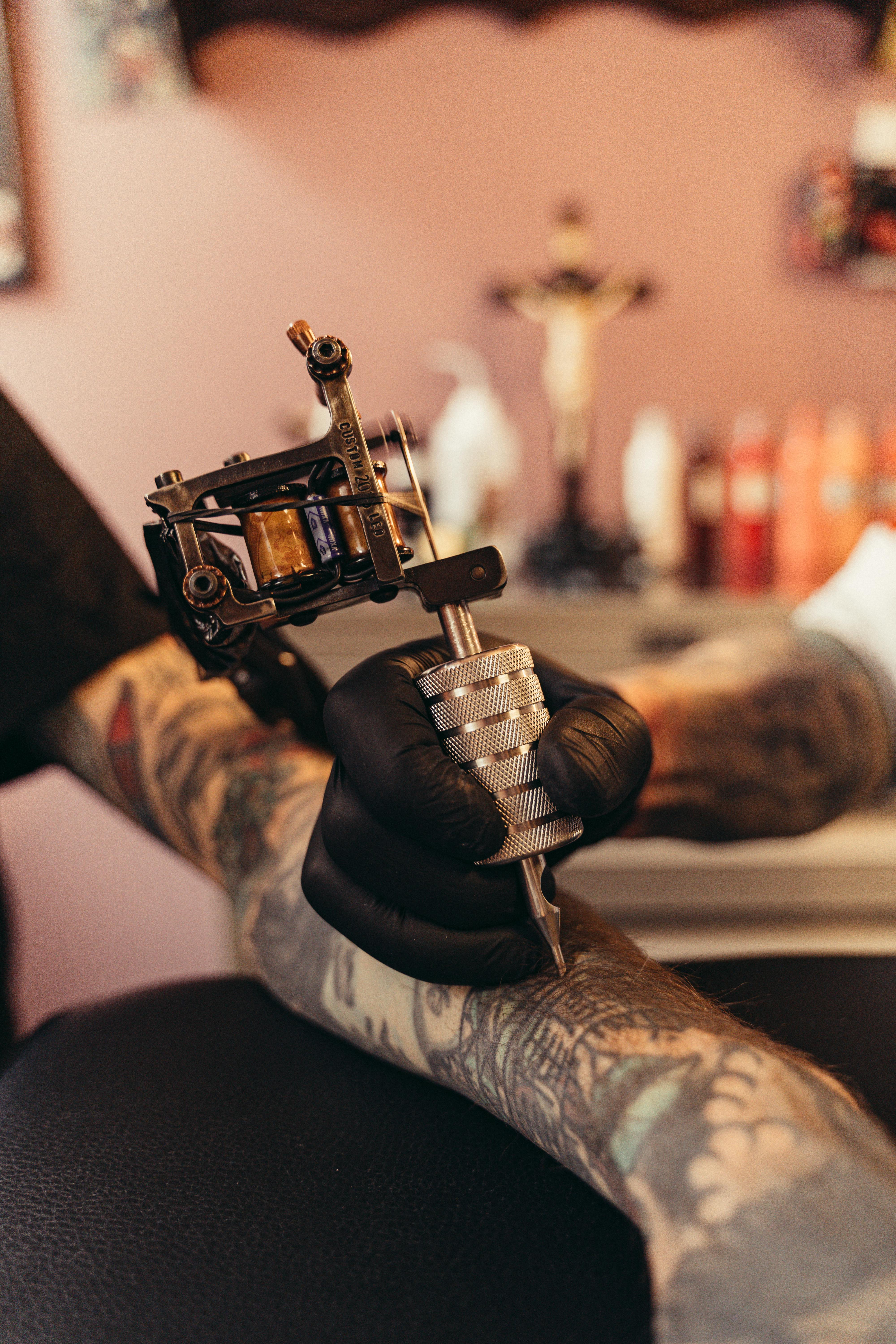 Tattooist With His Machine Tattooing On The Arm With The Design Drawn And  Using Protective Mask Against Covid 19 Concept Of Art And Design Stock  Photo Picture And Royalty Free Image Image 149668153