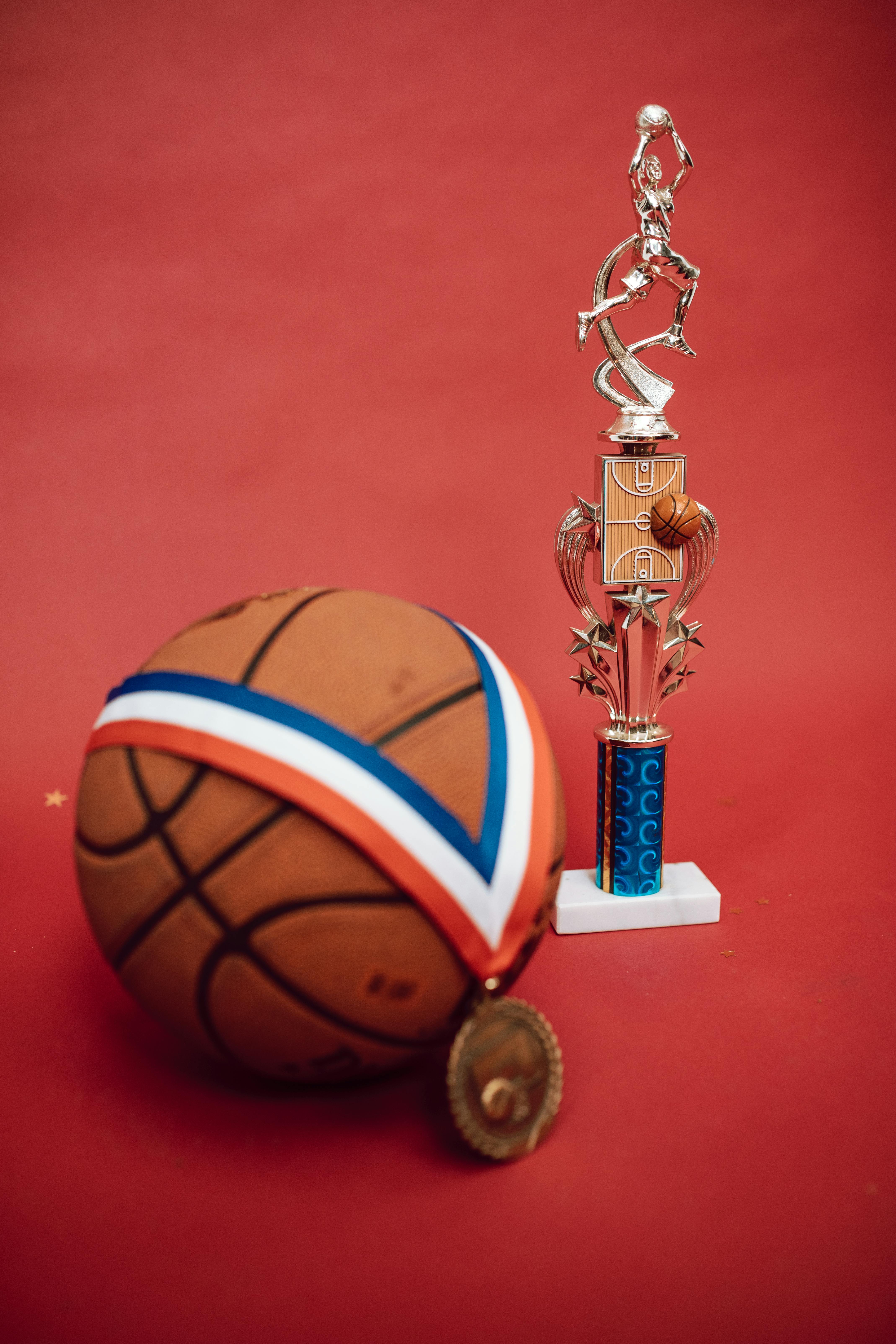 a medal on a ball and a basketball trophy
