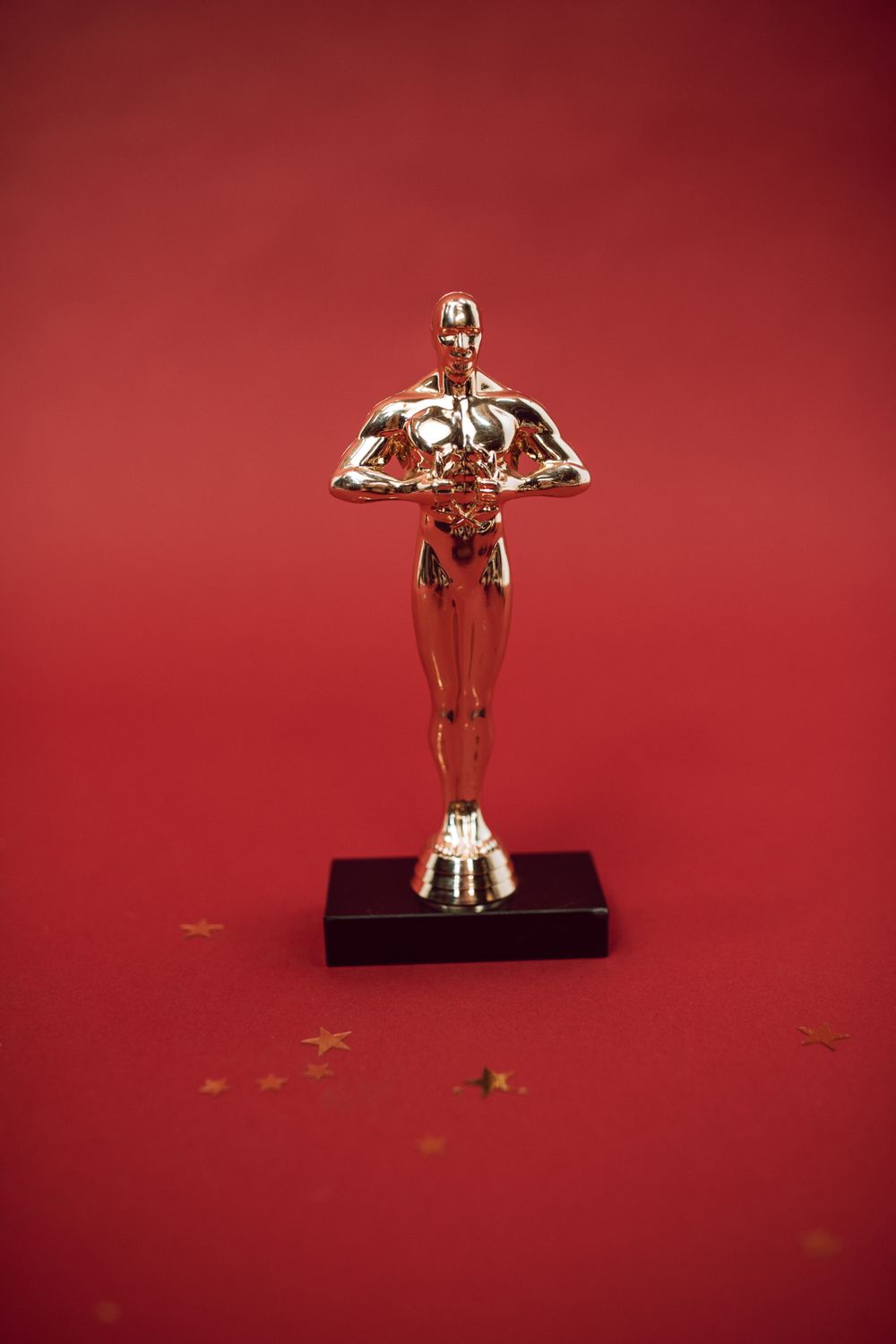 Close-up of a single golden Oscar statuette against a red backdrop, illustrative photo for the 2027 Academy Awards race