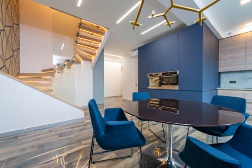 Modern dining room interior with furniture against staircase at home