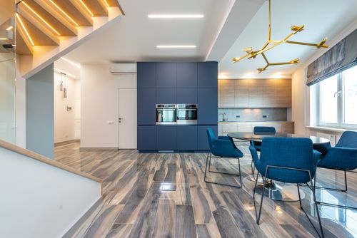 Free Table with armchairs on floor against cabinets and built in electric appliances in modern kitchen at home Stock Photo