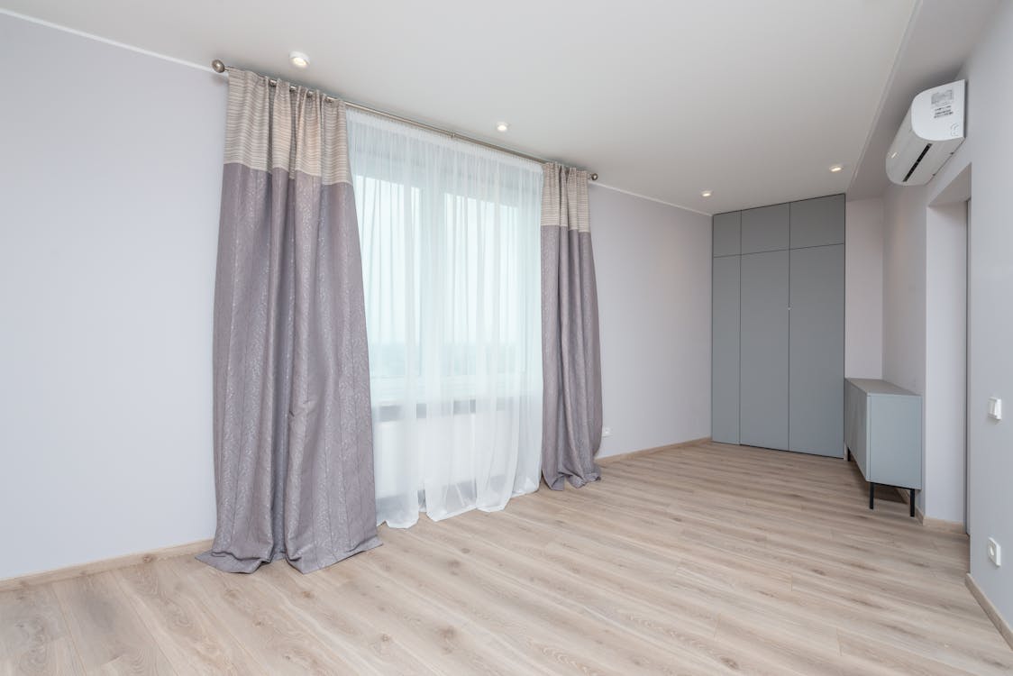 Empty room interior with parquet and curtains at home