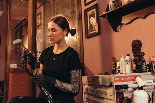 Free Tattoo artist in studio focusing on equipment and preparation. Stock Photo