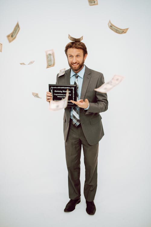 Money Falling on a Man Holding an Award