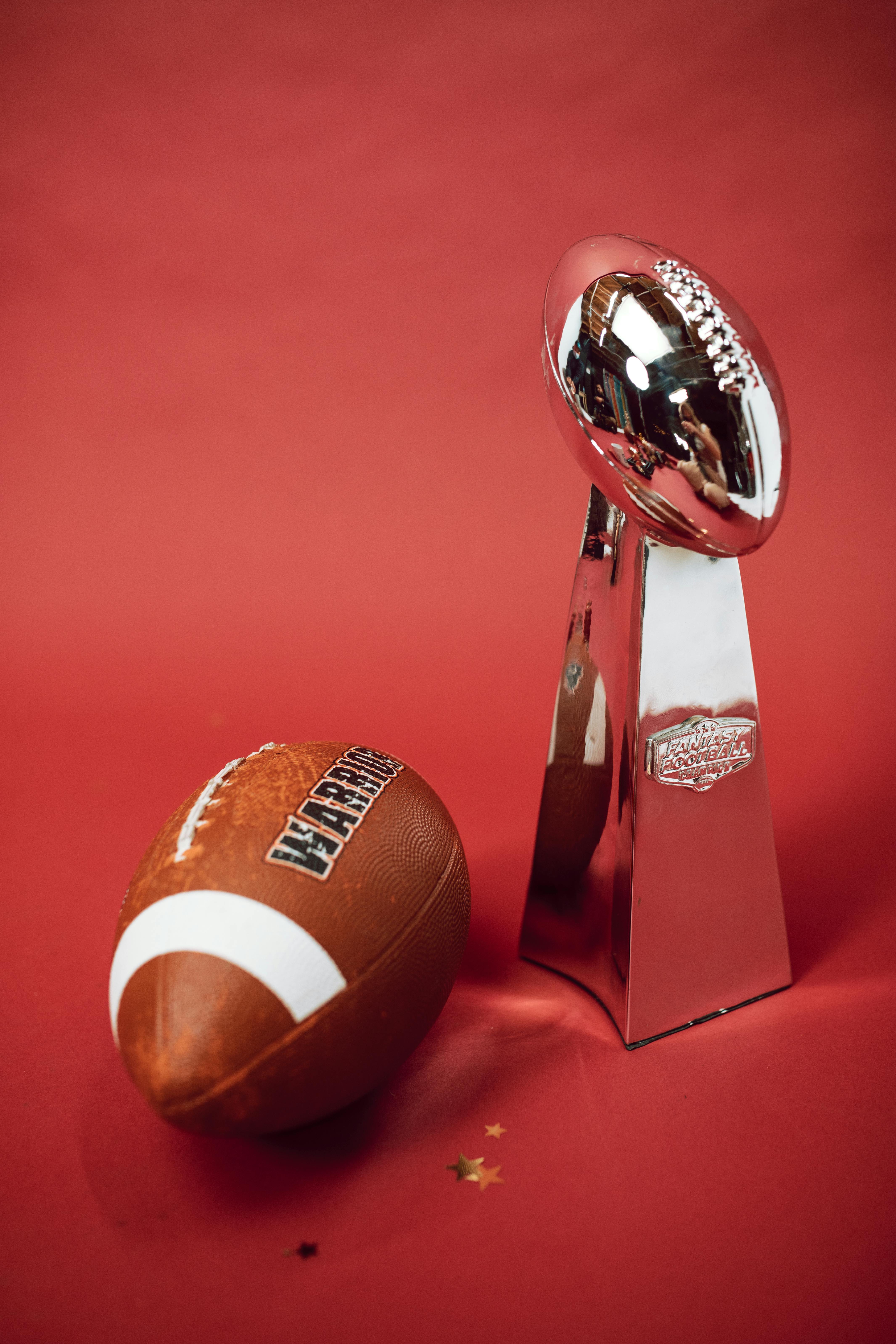 a pigskin football and a silver trophy