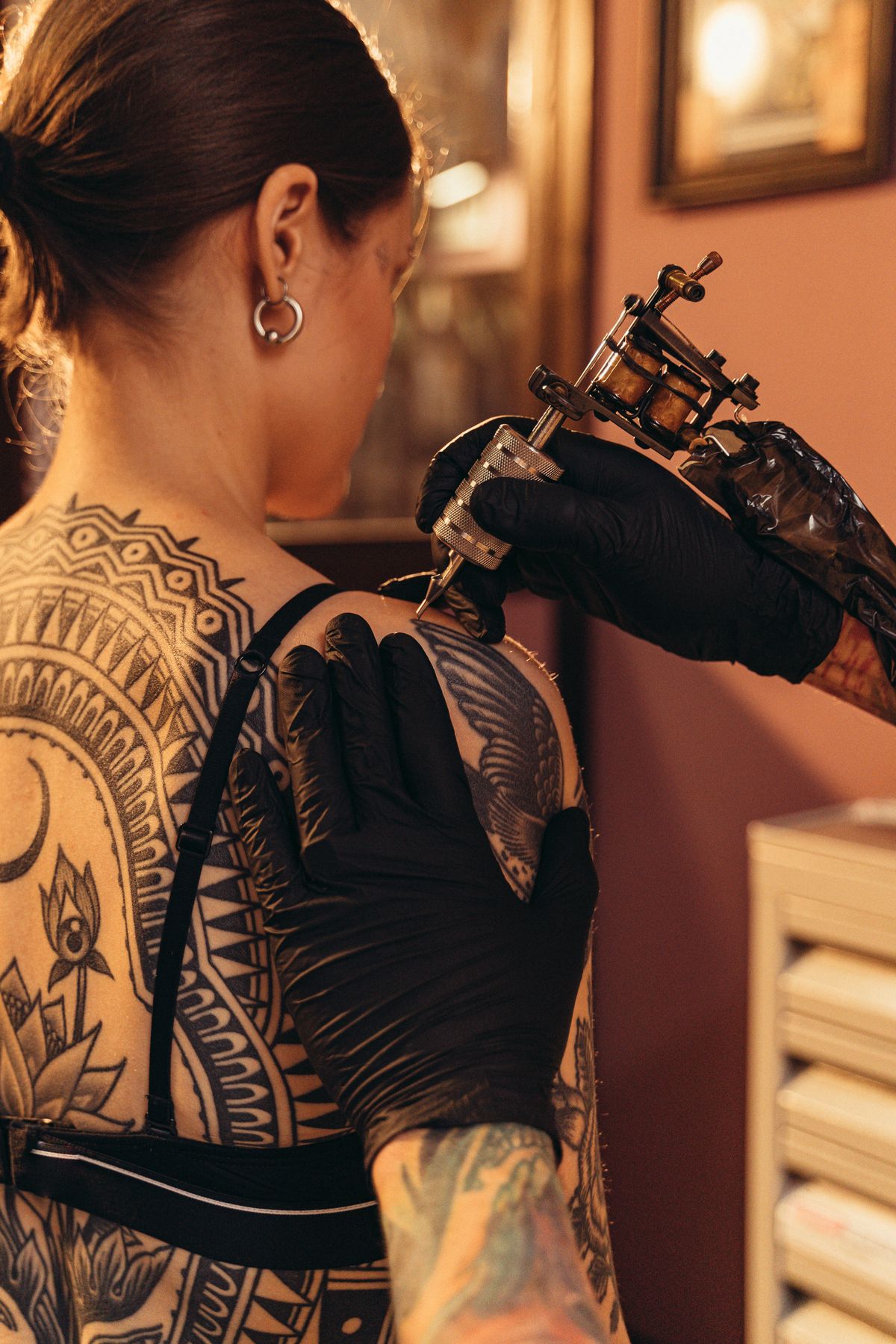 Tattoo machine working over a fully sleeved arm