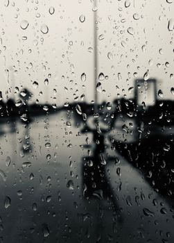Close-up view of raindrops on a glass window with cityscape background in Ottawa.