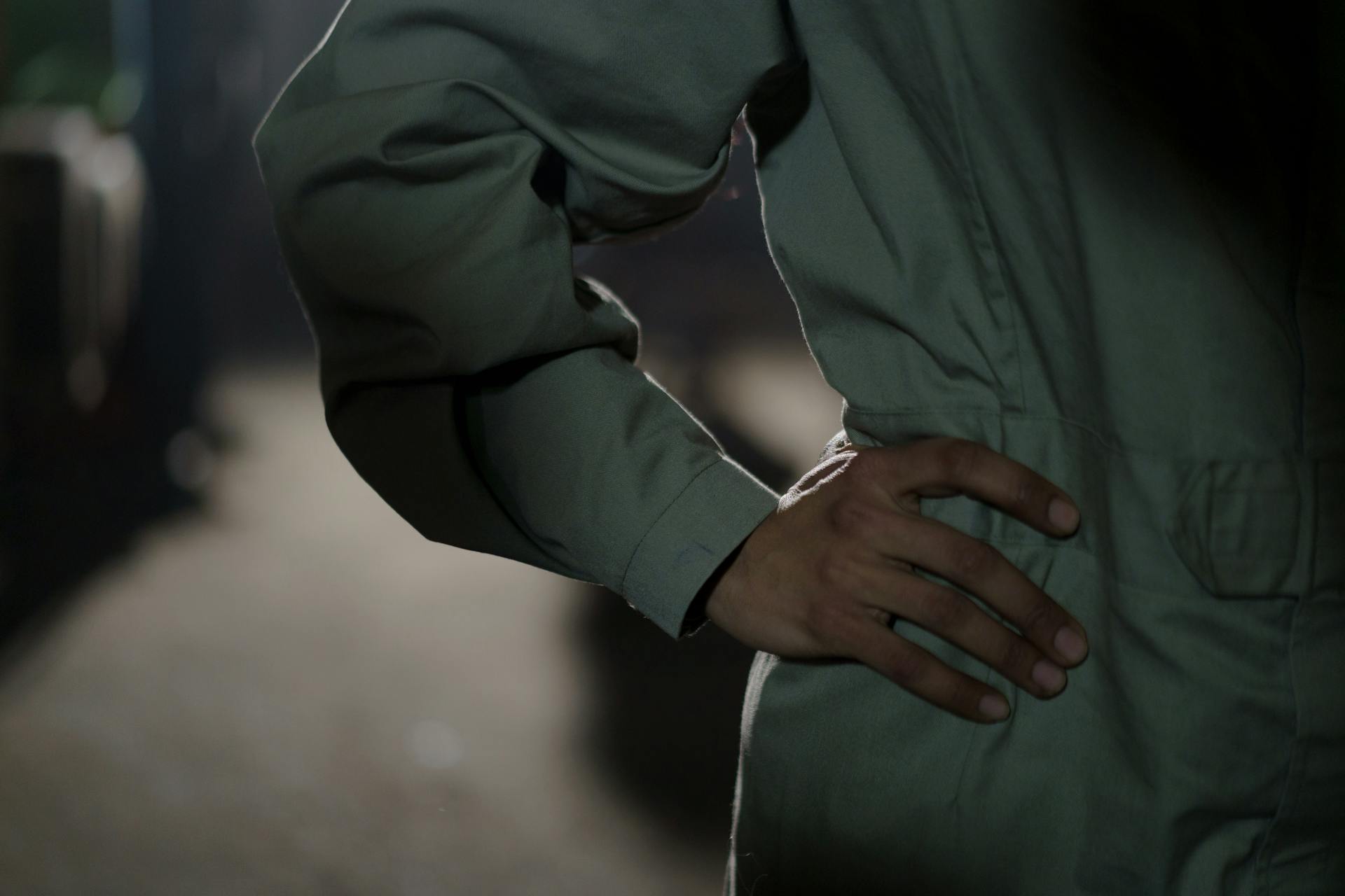 Close-up of a worker in a boiler suit posing with a hand on waist, creating a professional and industrial vibe.