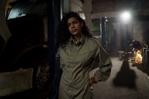 Free Portrait of a woman mechanic in a workshop, showcasing confidence and skill in a gritty industrial setting. Stock Photo