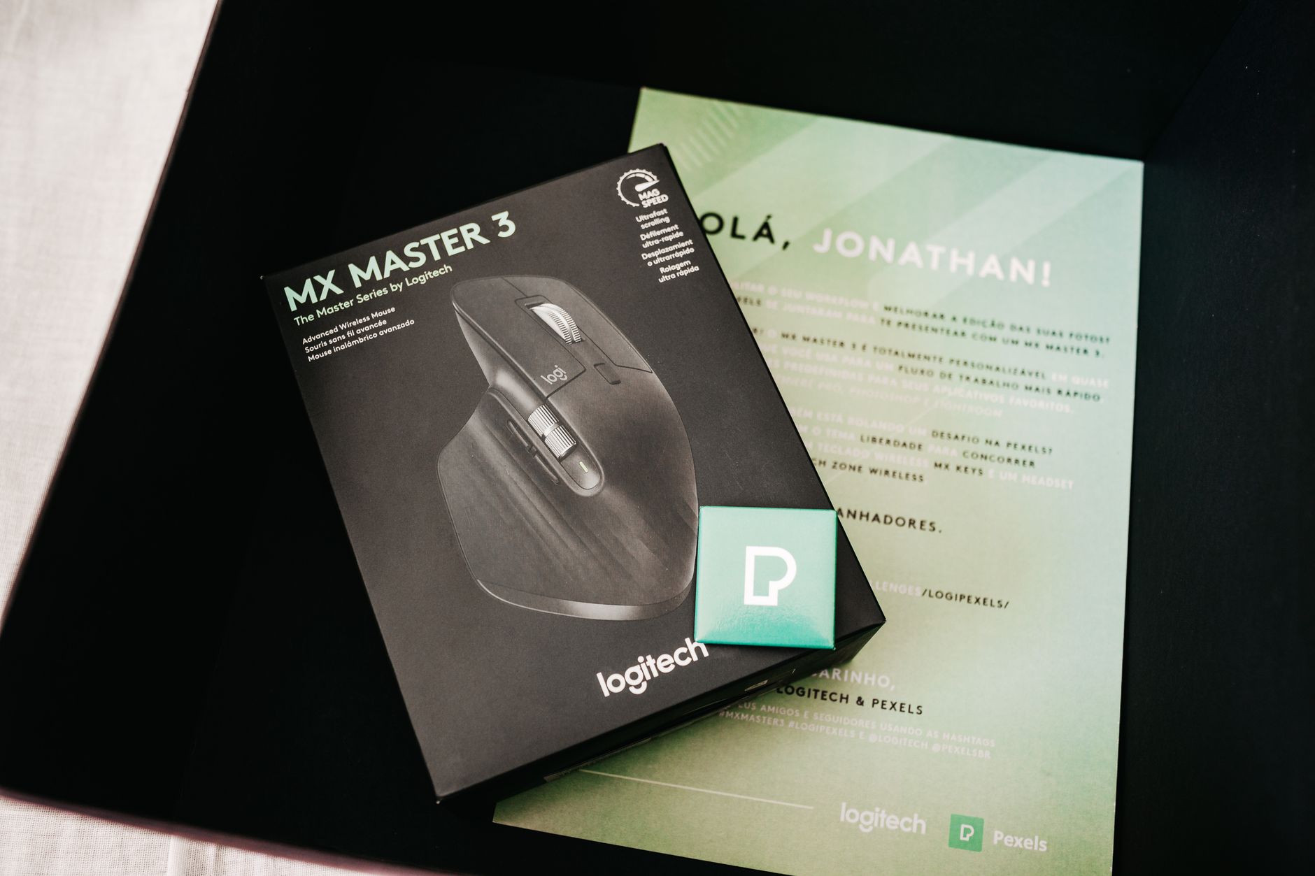 From above of black box with contemporary game mouse placed near personal certificate with name