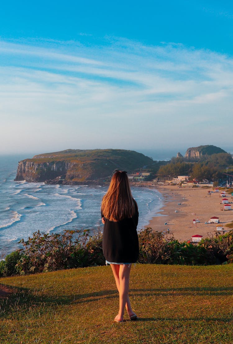 A Woman Standing On A Hill Overlooking A Guarita Beach In Torres, Brazil