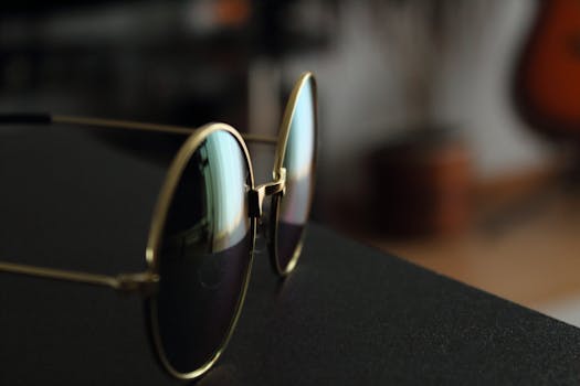 Elegant gold frame sunglasses with reflections captured indoors. by Ferenc Tóth