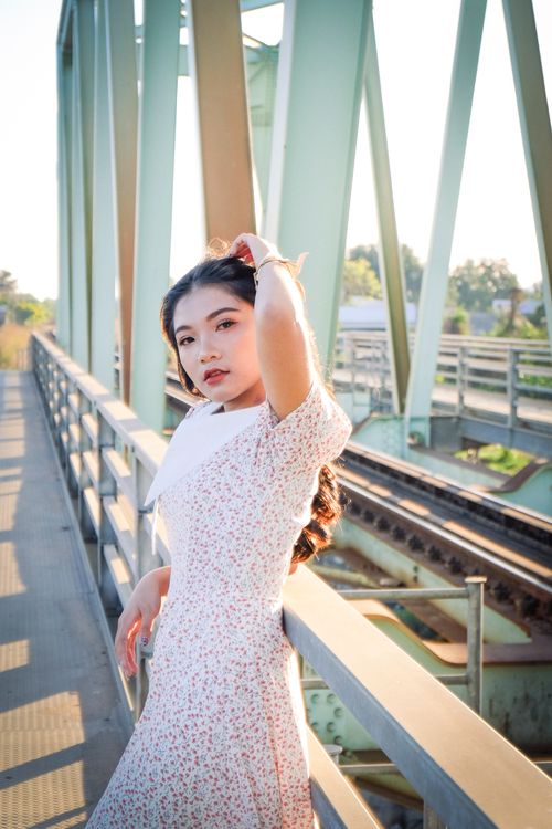 Free Stylish outdoor portrait of a woman on a bridge, showcasing vintage fashion. Stock Photo
