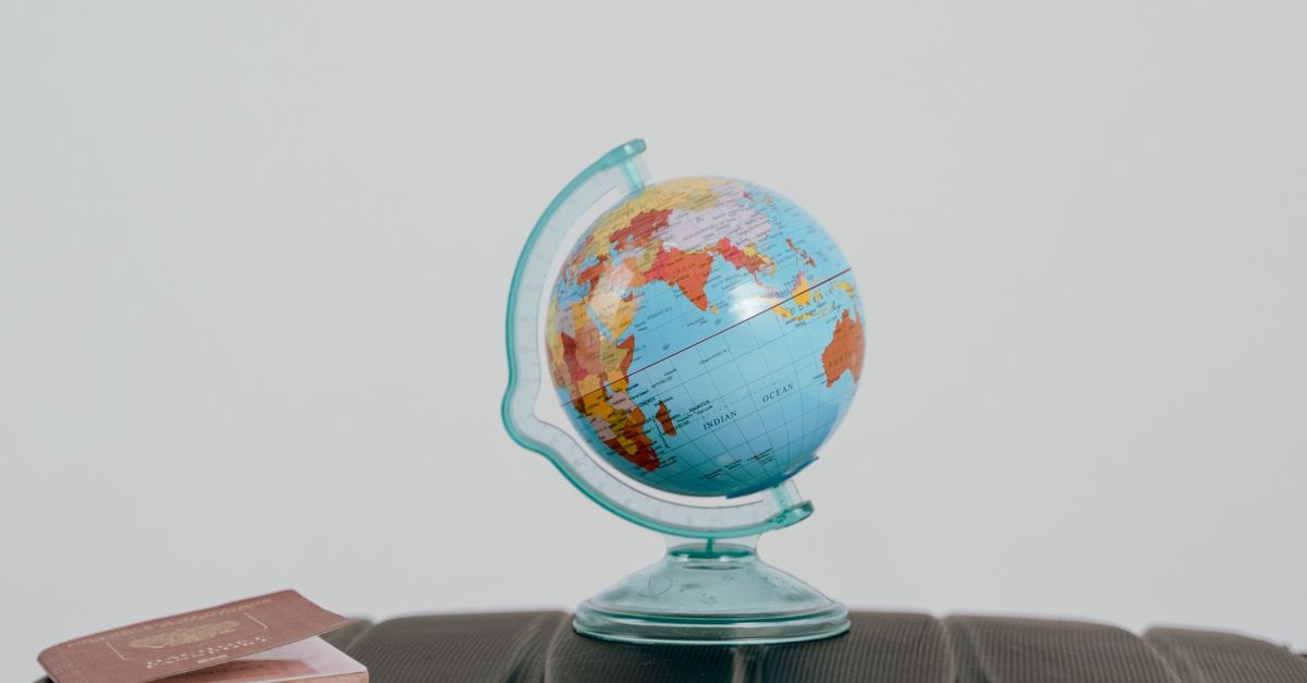 A globe and passport on a suitcase, symbolizing travel planning and wanderlust. visual (Photo: Tima Miroshnichenko / Pexels)