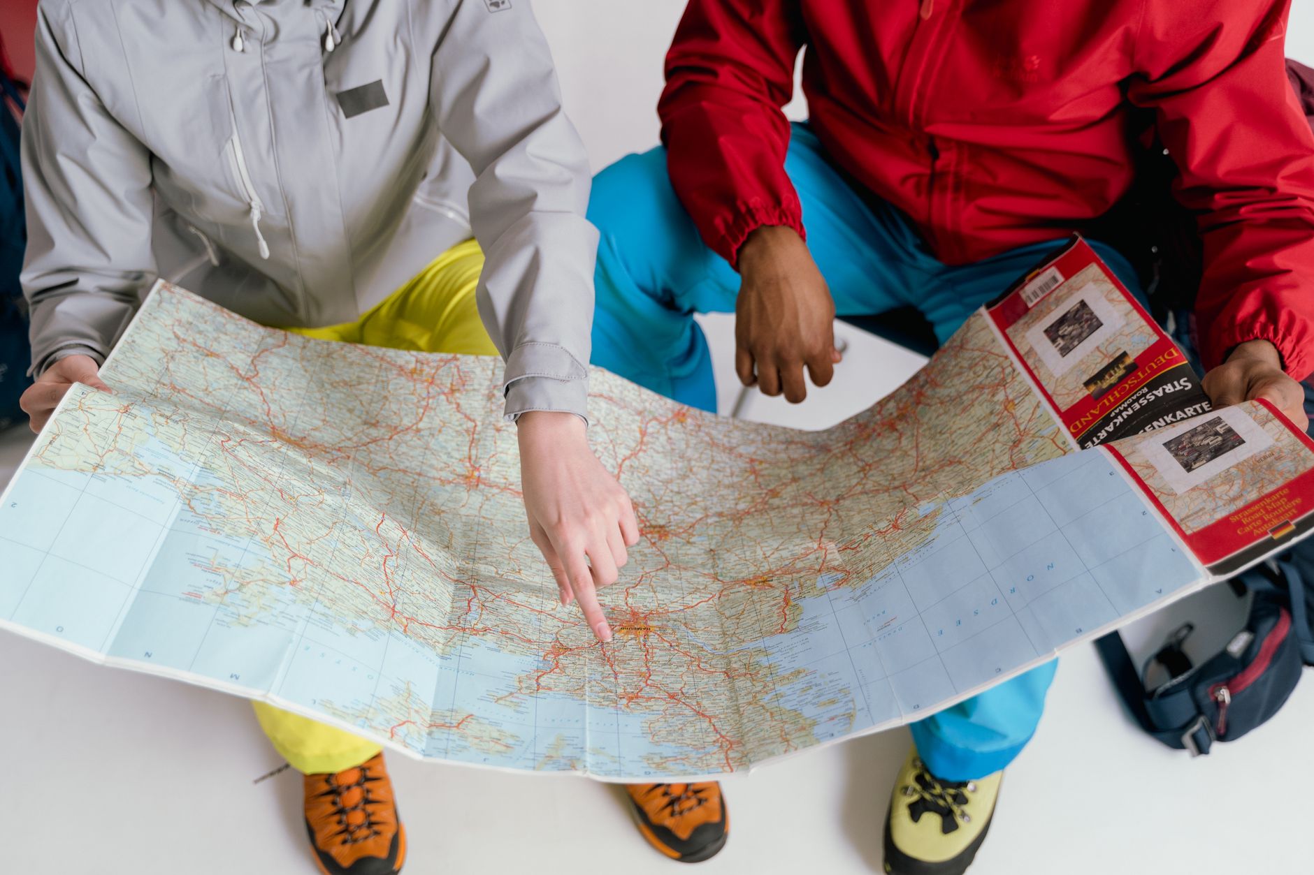 Deux voyageurs examinant une carte détaillée pour une aventure de randonnée en hiver.
