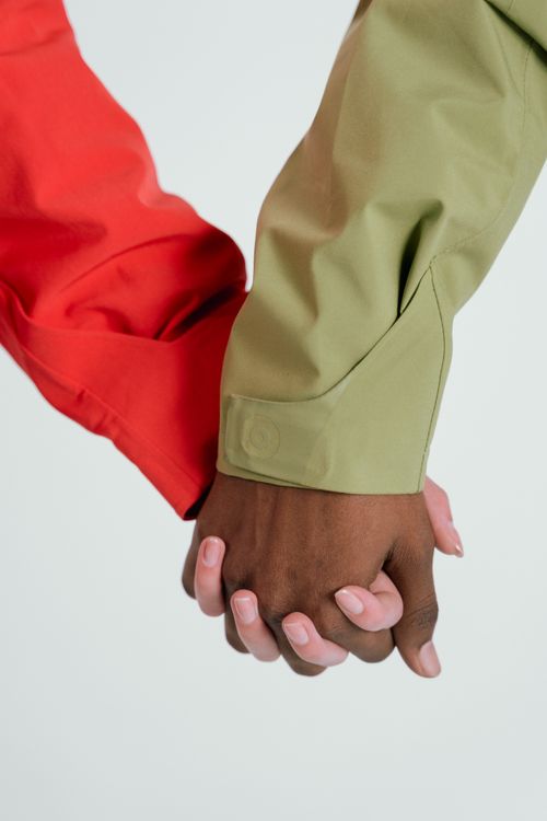 Free A close-up of two people holding hands, showcasing diversity and unity. Stock Photo