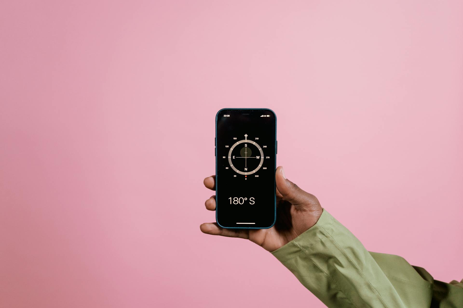 A Person Holding a Smartphone with Compass Mobile App