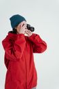 Man in Red Jacket and Blue Knit Cap Holding Black Dslr Camera