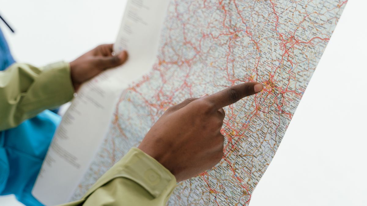 Close-up of hands holding a map for navigation and travel direction.