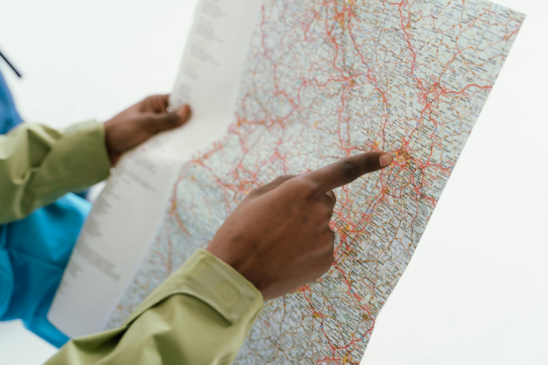 Close-up of hands holding a map for navigation and travel direction.