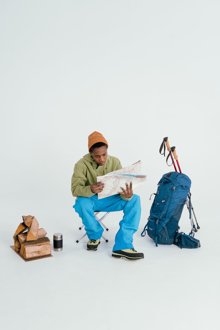 A Woman In Blue Pants Sitting While Holding A Map