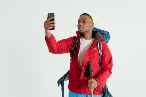 Man in Red Jacket looking at a Smartphone 