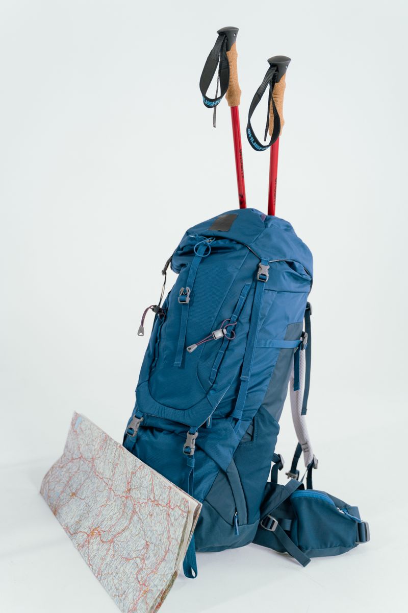 Rucksack mit Trekkingstöcken und Karte