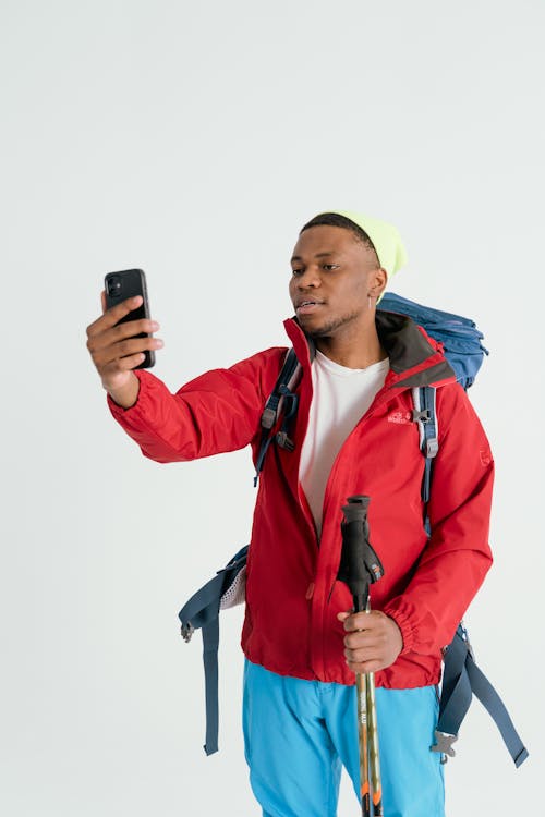 Man in Red Jacket looking at a Smartphone 