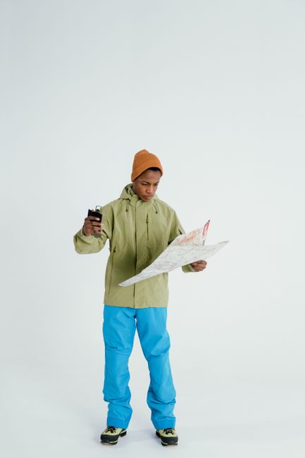 A hiker using a topographical map and compass for Olympic National Park trail navigation.
