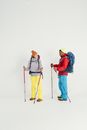 2 Men in Blue and Yellow Jacket and Yellow Knit Cap Holding Sticks