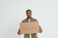 Man in Green Long Sleeve Shirt Holding Brown Cardboard